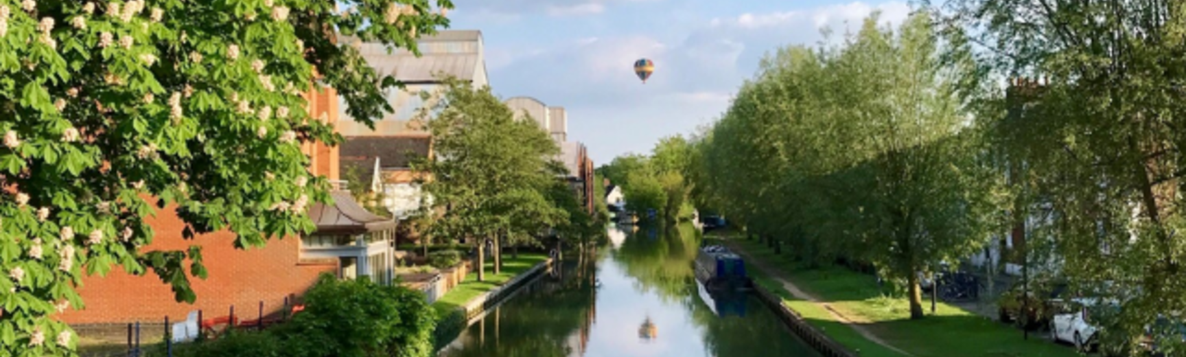 Photo of the Oxford canal with a hot air ballon in the sky above