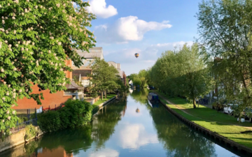 Photo of the Oxford canal with a hot air ballon in the sky above